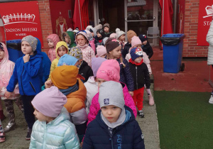 Dzieci stoją przed wejściem na stadion klubu