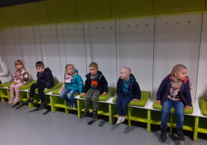 Dzieci siedzą w szatni gości