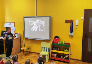 Dzieci oglądają slajd na tablicy multimedialnej.