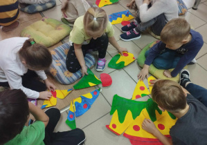 Dzieci wykonują kolejne zadanie, które polega na ułożeniu puzzli w kształcie tortu Mary Poppins.