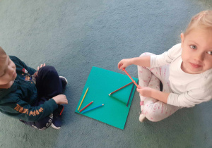 Dzieci układają wzory z kredek