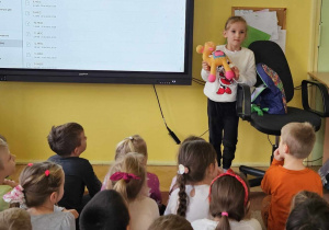 Dziewczynka pokazuje maskotkę wielbłąda.