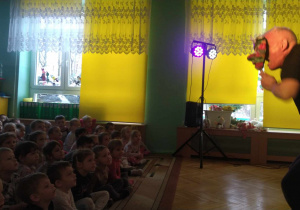 Dzieci siedzą w sali i oglądają przedstawienie