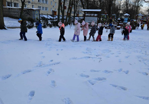 Dzieci idą po śladach na śniegu
