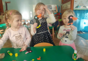 Dziewczynki prezentują pingwiny wykonane z kół origami