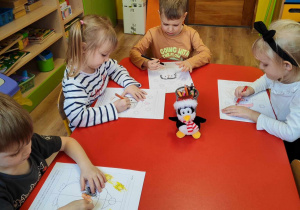 dzieci kolorują obrazek z pingwinem