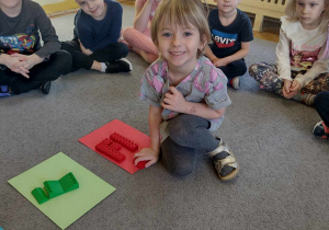 Dzieci przyporządkowują klocki do kolorowych kartek, a później rozwiązują zagadki matematyczne