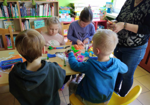 Dzieci siedzą i projektują swoją łąkę z nieużytków.