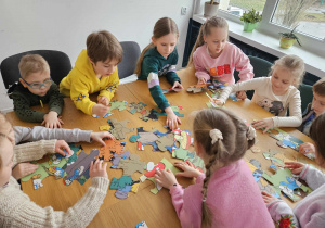 Dzieci układają puzzle w grupie