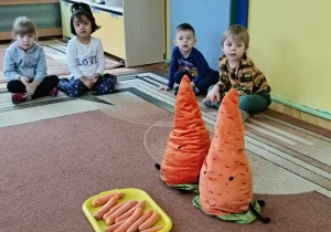 Na dywanie znajdują się pluszowe marchewki, które opowiadają ciekawostki o marchewkach