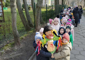 dzieci spacerują, w ręku trzymają Marzannę