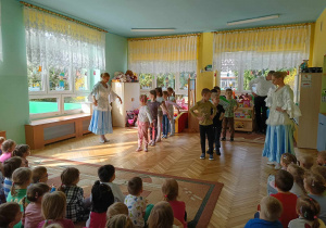 dwie tancerki uczą kroków poloneza. Na środku sali stoją dzieci i prezentują kroki