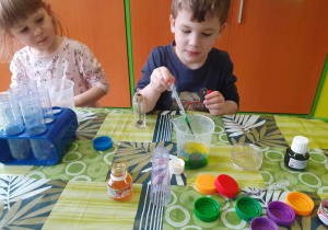 Chłopiec miesza ze sobą różne kolory tuszu.