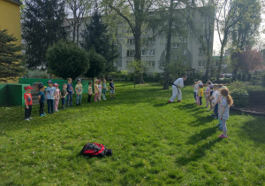 Dzieci podzielone na dwie drużyny biorą udział w zabawie ruchowej