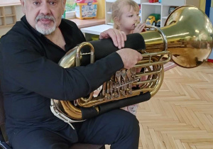 Gabrysia próbuje grać na instrumencie dętym