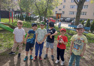 Sześciu chłopców pozuje do zdjęcia podczas zabaw w ogrodzie