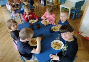 Dzieci ze smakiem zjadają hiszpańską paellę