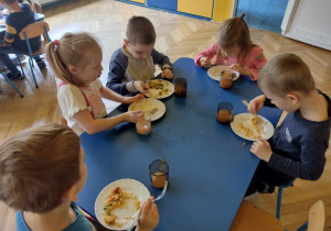 Dzieci ze smakiem zjadają hiszpańską paellę