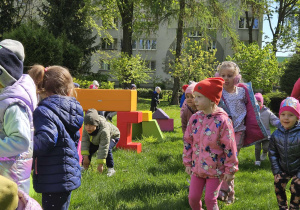Dzieci biorą udział w zabawach ruchowych w ogrodzie przedszkolnym