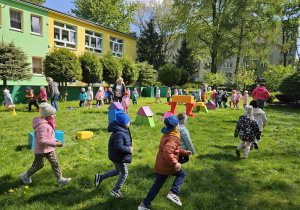 Dzieci biorą udział w zabawach ruchowych w ogrodzie przedszkolnym