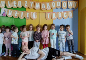 Dzieci wraz z instruktorem tańca pozują do zdjęcia grupowego