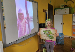 Dziewczynka pokazuje mapę i zdjęcia z podróży.