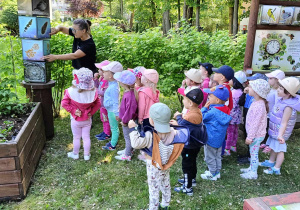 Dzieci oglądają tablice edukacyjne dotyczące ptaków, ich upierzenia, pokarmu i jaj