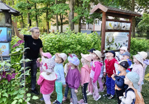 Dzieci oglądają tablice edukacyjne dotyczące ptaków, ich upierzenia, pokarmu i jaj