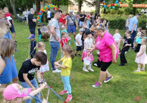 Dzieci wraz z rodzicami podczas wspólnych zabaw w ogrodzie przedszkolnym