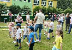 Dzieci wraz z rodzicami podczas wspólnych zabaw w ogrodzie przedszkolnym