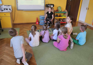 Dziewczynka pokazuje zdjęcia na tablicy multimedialnej.