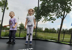 dzieci skaczą na trampolinie