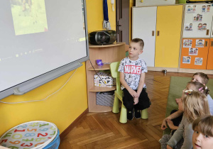 Chłopiec pokazuje zdjęcia na tablicy multimedialnej.