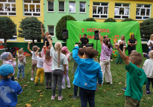 Dzieci wraz z rodzicami biorą udział we wspólnych zabawach w ogrodzie przedszkolnym