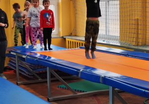 dzieci skaczą na trampolinach