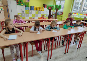 dzieci rozwiązują zadania: układają puzzle, rysują krasnoludka oraz wykonują zadanie matematyczne