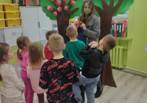 Dzieci szukają na drzewie jabłek