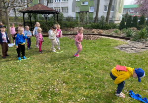 Dzieci biorą udział w konkurencjach sportowych w ogrodzie przedszkolnym.