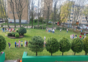 Dzieci biorą udział w konkurencjach sportowych w ogrodzie przedszkolnym.