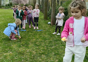 Dzieci biorą udział w konkurencjach sportowych w ogrodzie przedszkolnym.