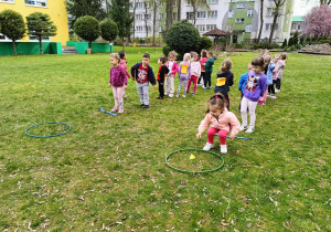 Dzieci biorą udział w konkurencjach sportowych w ogrodzie przedszkolnym.