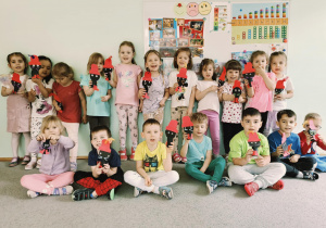 dzieci pozują do zdjęcia grupowego z wykonanymi przez siebie pacynkami
