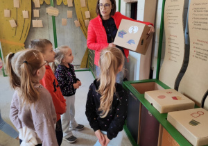 dzieci segregują śmieci do odpowiednich pojemników