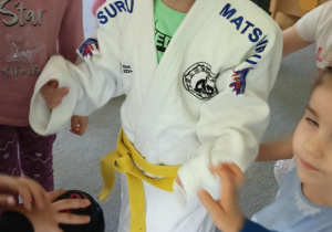 dzieci przymierzają strój do trenowania judo