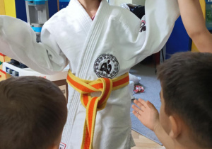 dzieci przymierzają strój do trenowania judo