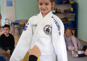 dzieci przymierzają strój do trenowania judo