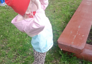 dziewczynka obserwuje przyrodę przez eko-lornetkę w ogrodzie przedszkolnym