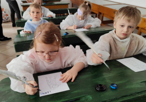 dzieci piszą gęsim piórem,