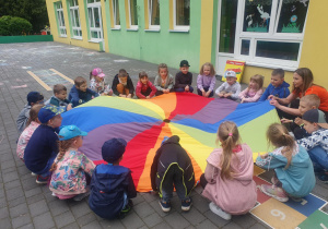 Dzieci bawią się z chustą animacyjną.