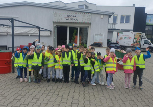 Dzieci pozują do zdjęcia grupowego przed pizzerią